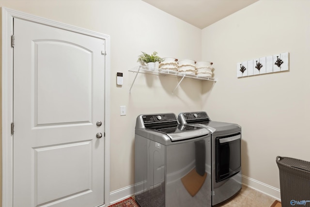 washroom featuring washer and dryer, baseboards, laundry area, and light tile patterned floors