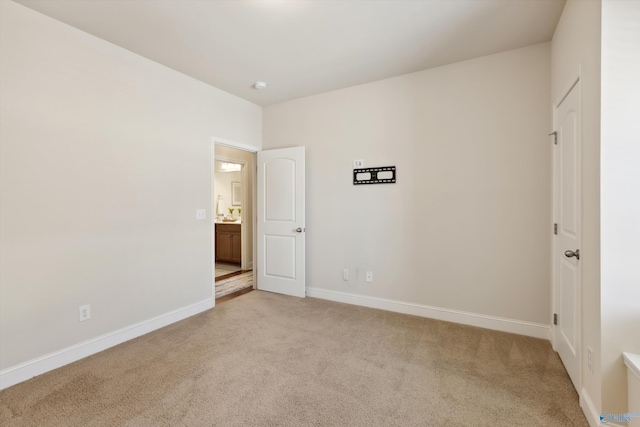 unfurnished bedroom featuring light colored carpet and baseboards