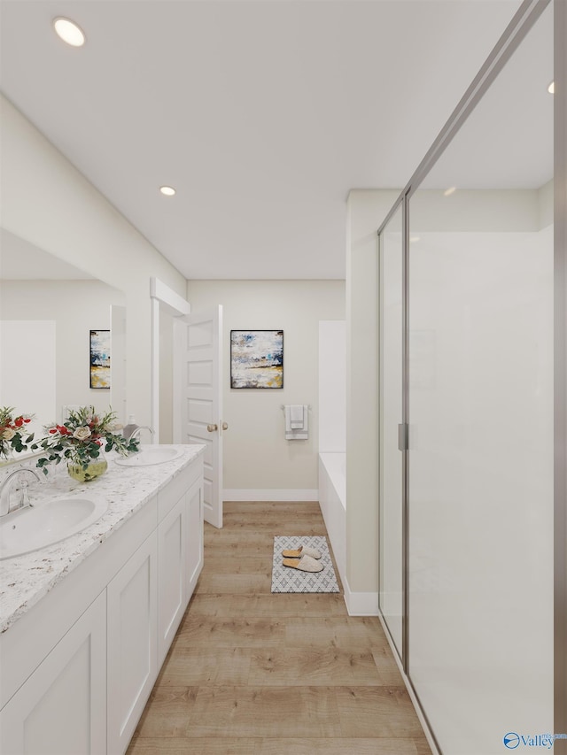 bathroom with vanity, hardwood / wood-style flooring, and shower with separate bathtub