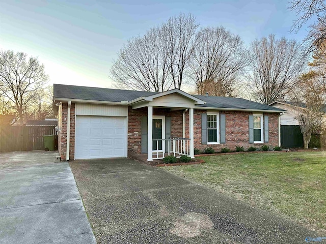 ranch-style home featuring a garage and a front lawn