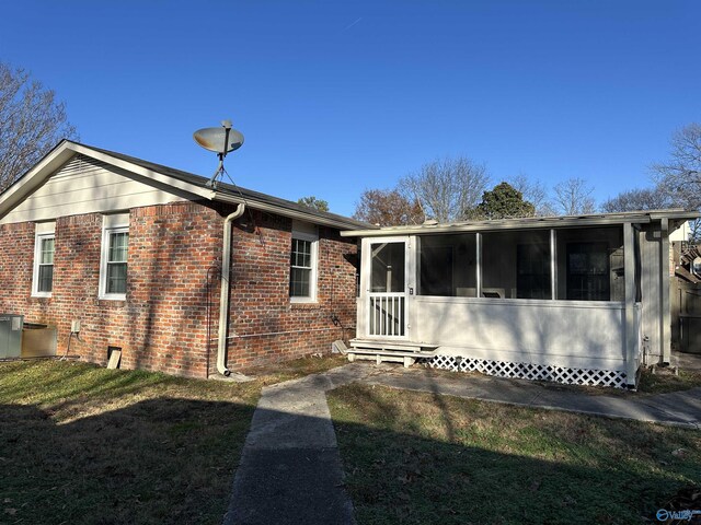 view of front of home featuring a front lawn and a sunroom