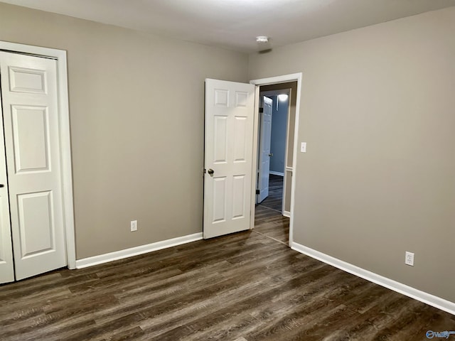 unfurnished bedroom featuring a closet and dark hardwood / wood-style floors