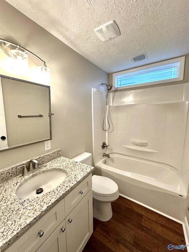 full bathroom featuring plenty of natural light, shower / bath combination, a textured ceiling, and hardwood / wood-style flooring