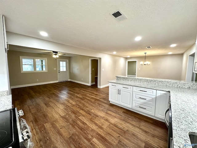 kitchen featuring light stone counters, pendant lighting, white cabinets, and dark wood-type flooring