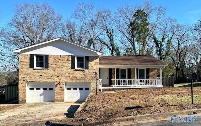 tri-level home featuring covered porch, a garage, brick siding, fence, and concrete driveway