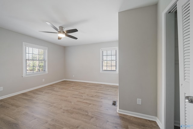 unfurnished bedroom with a closet, visible vents, light wood-style flooring, ceiling fan, and baseboards