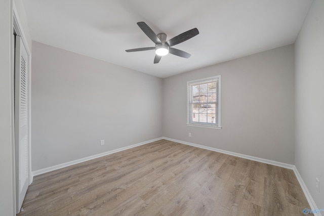 spare room with ceiling fan, light wood-style flooring, and baseboards