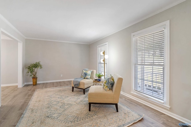 sitting room with crown molding, baseboards, and wood finished floors