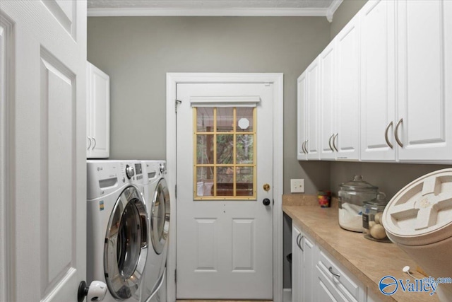 laundry room featuring cabinets, washing machine and dryer, and ornamental molding