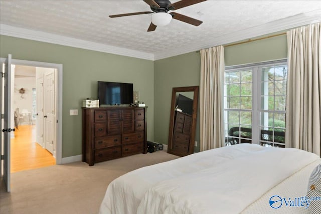 carpeted bedroom with a textured ceiling, ceiling fan, and crown molding