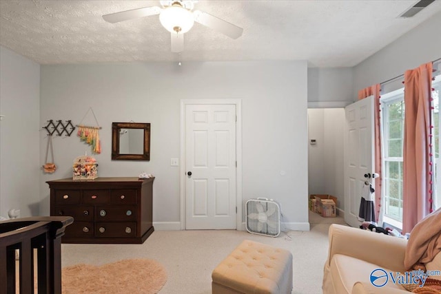 carpeted bedroom featuring a textured ceiling and ceiling fan