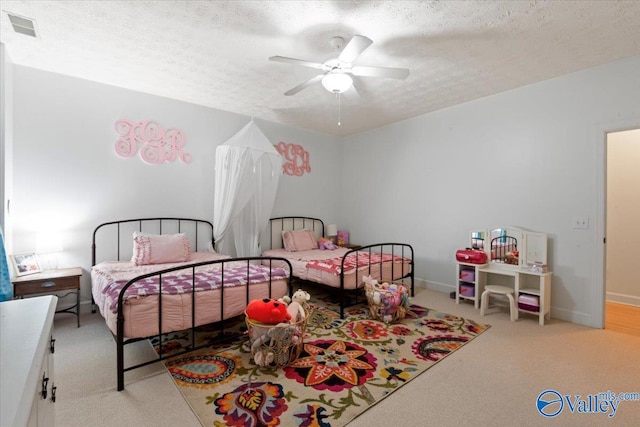 carpeted bedroom with a textured ceiling and ceiling fan