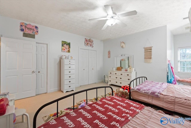 bedroom featuring carpet flooring, ceiling fan, and a textured ceiling