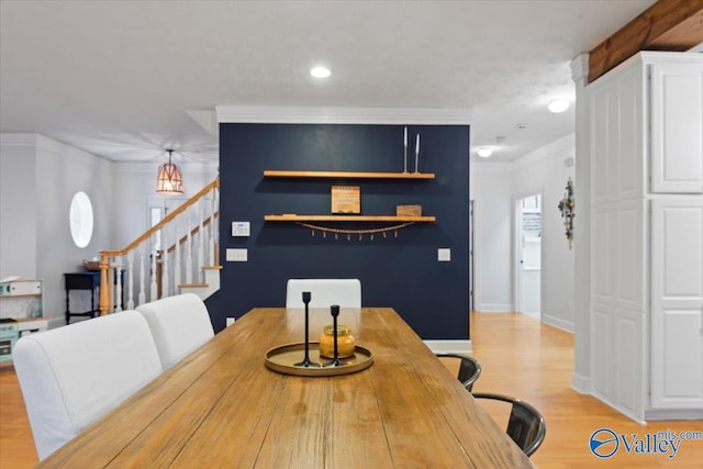 dining space with light hardwood / wood-style flooring and ornamental molding