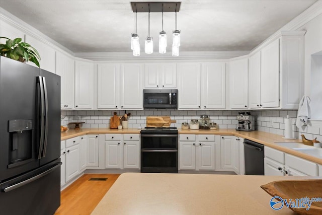 kitchen with black appliances, white cabinetry, hanging light fixtures, and tasteful backsplash