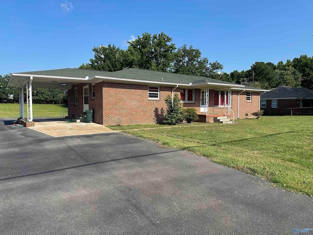 ranch-style home featuring a carport and a front lawn