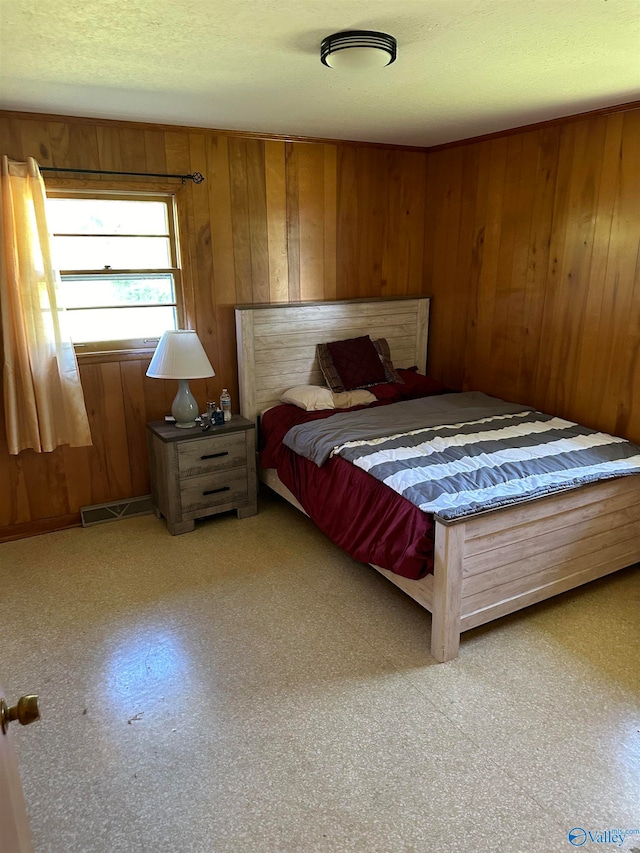 bedroom with wood walls and a textured ceiling