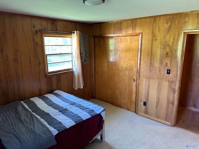 bedroom featuring a textured ceiling, wood walls, and a closet