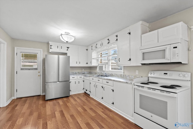 905 Cedar St SW, Decatur, AL 35601 - kitchen with white appliances, light countertops, white cabinets, and light wood finished floors
