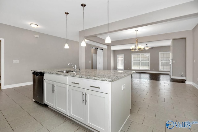 kitchen featuring light tile patterned floors, a barn door, a sink, open floor plan, and stainless steel dishwasher