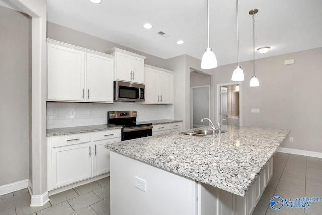 kitchen featuring light tile patterned floors, white cabinets, a sink, stainless steel appliances, and backsplash