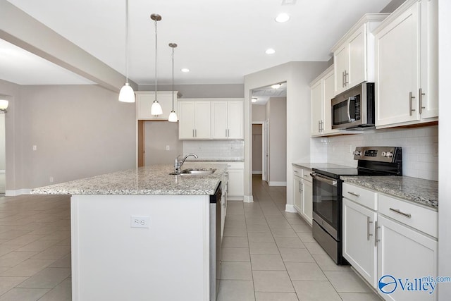 kitchen with stainless steel appliances, a sink, a center island with sink, and light tile patterned floors