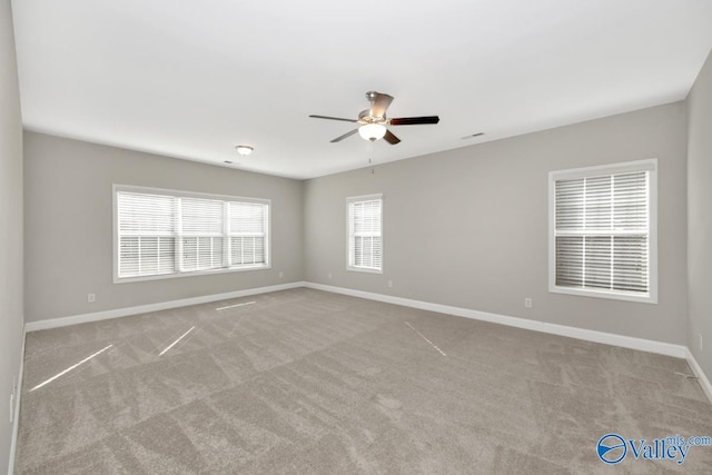carpeted empty room featuring a ceiling fan and baseboards