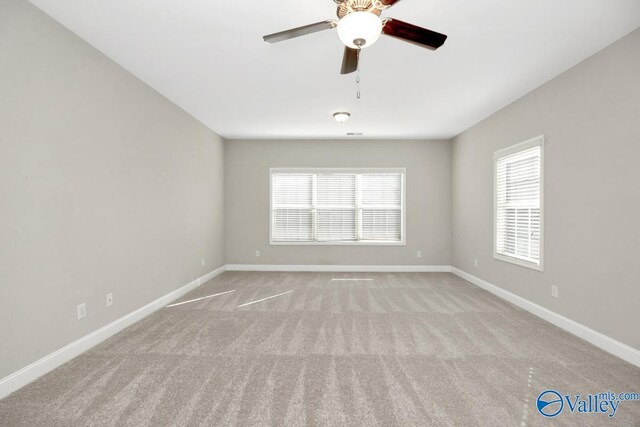 empty room featuring light carpet, ceiling fan, and baseboards