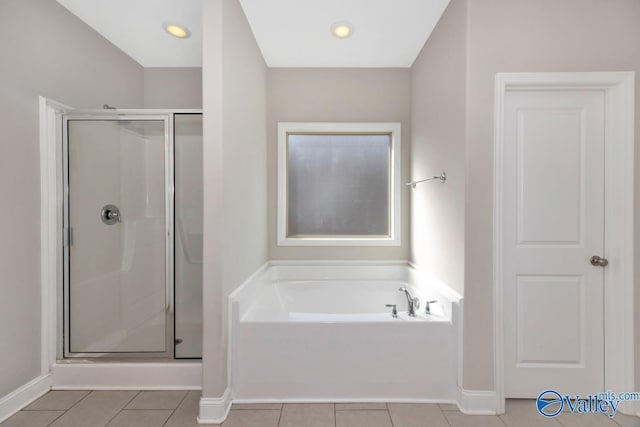 full bathroom featuring a garden tub, baseboards, tile patterned flooring, and a shower stall