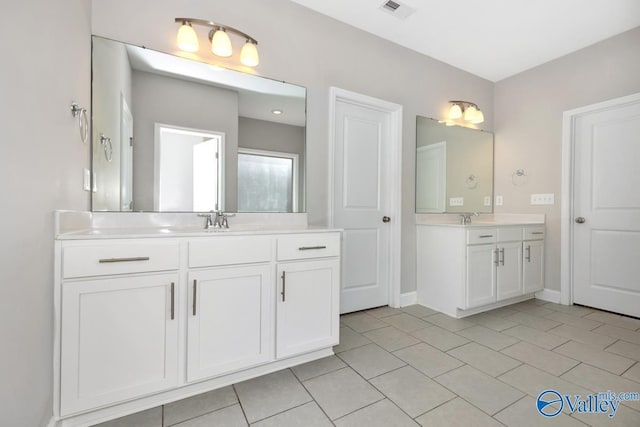 bathroom featuring a sink, two vanities, visible vents, and tile patterned floors