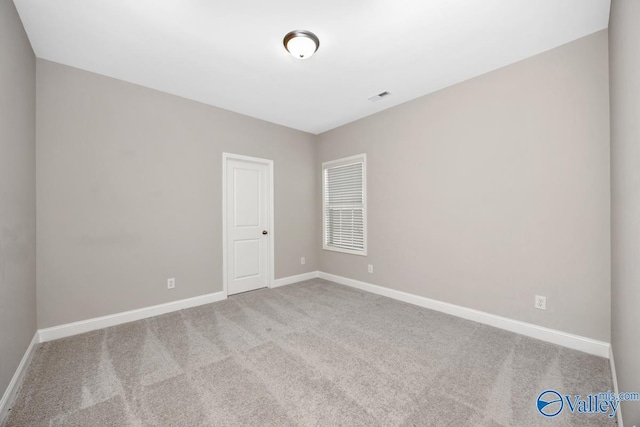 carpeted empty room with visible vents and baseboards
