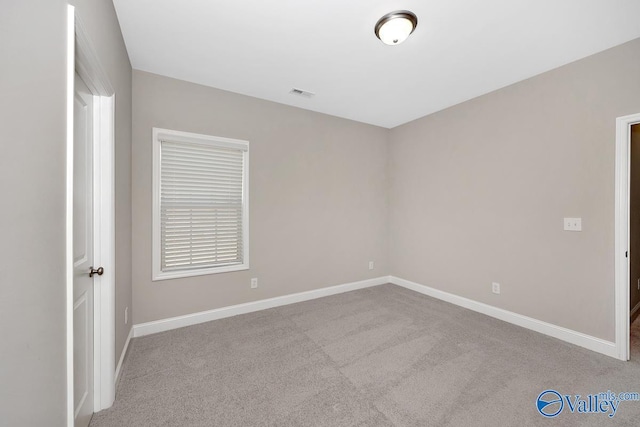carpeted empty room with visible vents and baseboards