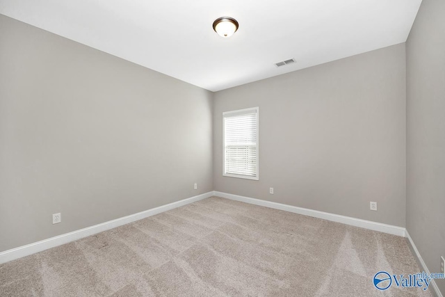 carpeted empty room featuring visible vents and baseboards