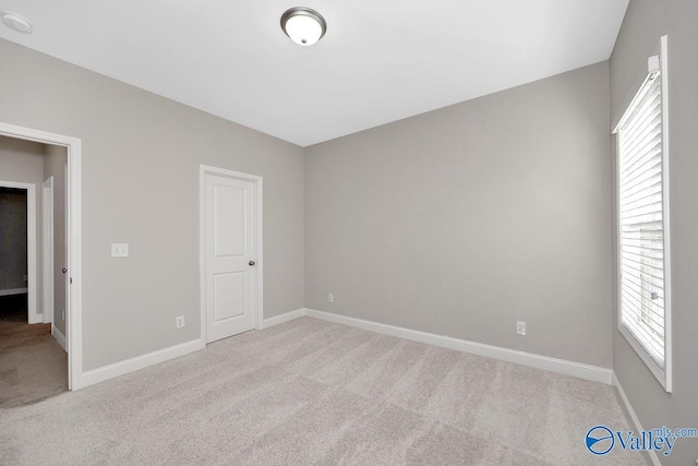 unfurnished bedroom with light carpet and baseboards