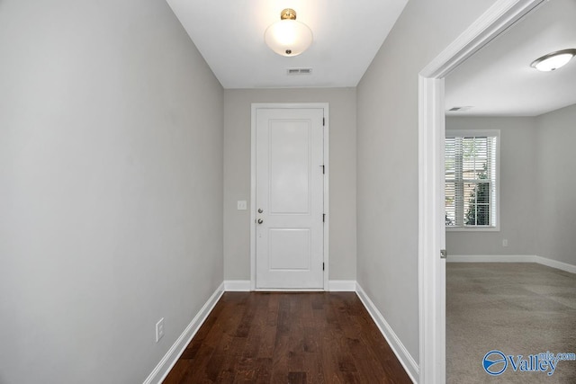 corridor with visible vents, baseboards, and wood finished floors