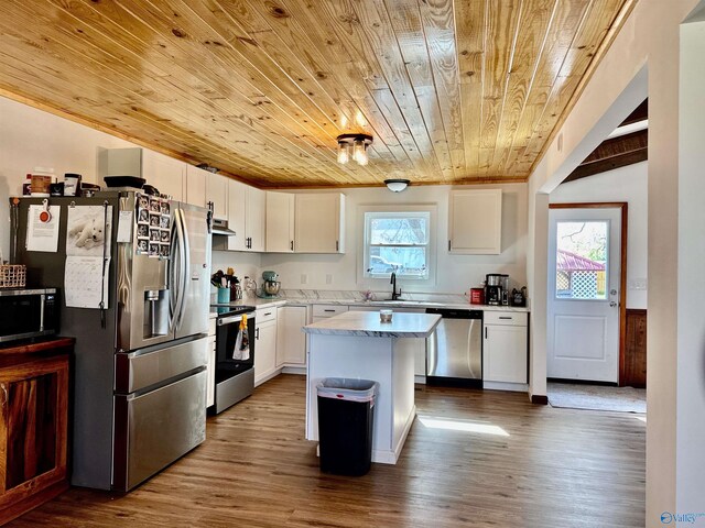 kitchen featuring dark wood-style flooring, white cabinets, a kitchen island, appliances with stainless steel finishes, and a sink