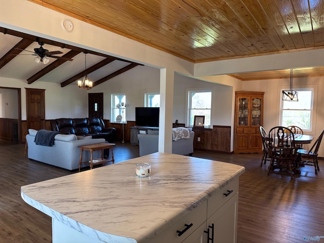kitchen with white cabinetry, a wainscoted wall, lofted ceiling with beams, and a wealth of natural light