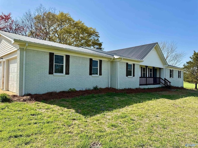 exterior space featuring brick siding, a lawn, a garage, and metal roof