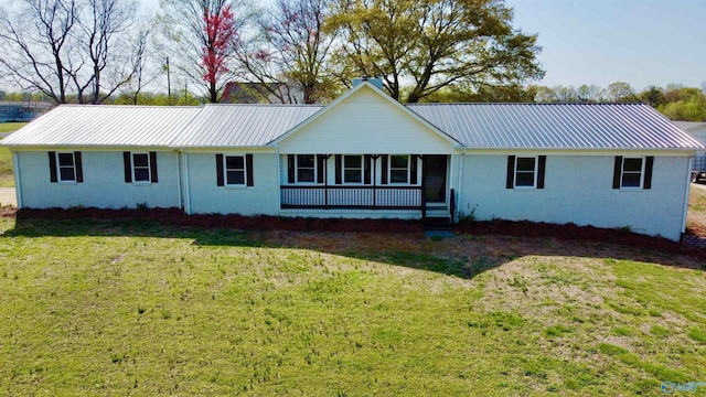 view of front facade with a front lawn, metal roof, and stucco siding