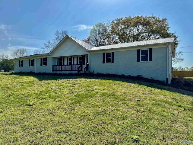single story home featuring covered porch, brick siding, metal roof, and a front lawn