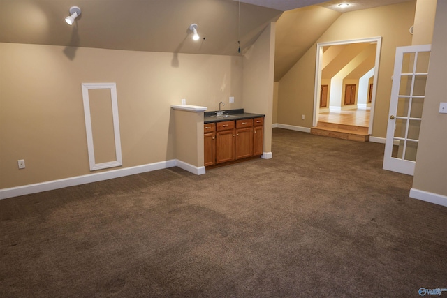 interior space featuring dark colored carpet and vaulted ceiling