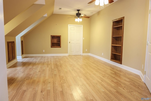 bonus room featuring light wood-type flooring, built in features, ceiling fan, and vaulted ceiling