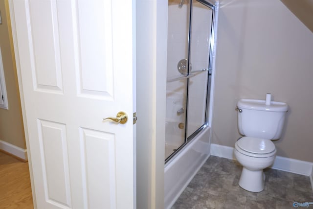 bathroom featuring enclosed tub / shower combo and toilet