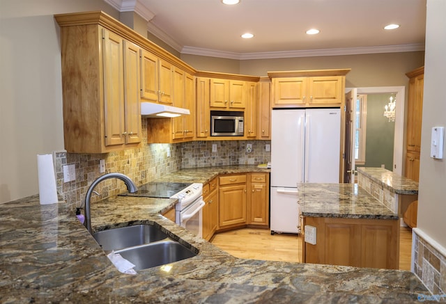 kitchen with backsplash, ornamental molding, dark stone counters, and appliances with stainless steel finishes