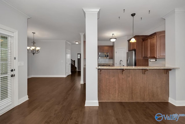 kitchen with kitchen peninsula, appliances with stainless steel finishes, crown molding, and dark hardwood / wood-style flooring