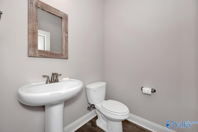 bathroom featuring hardwood / wood-style flooring and toilet