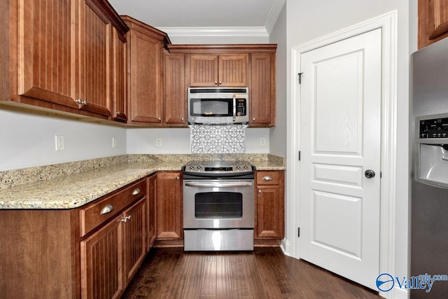 kitchen with ornamental molding, stainless steel appliances, light stone counters, and dark hardwood / wood-style flooring