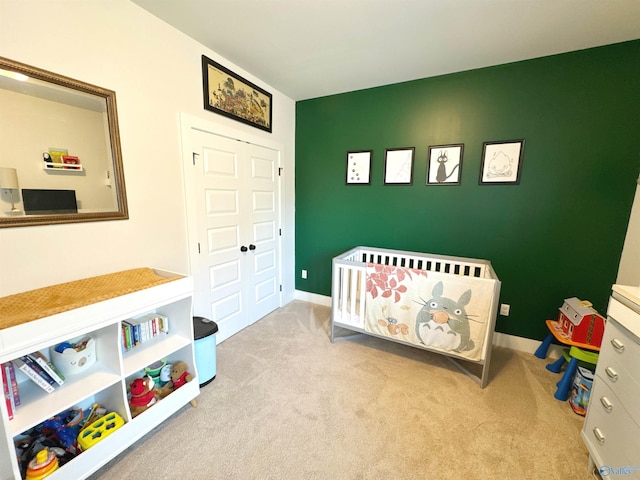 carpeted bedroom with baseboards and a crib