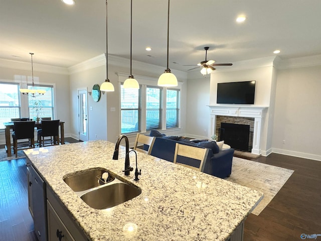 kitchen with recessed lighting, a sink, dishwashing machine, and an island with sink