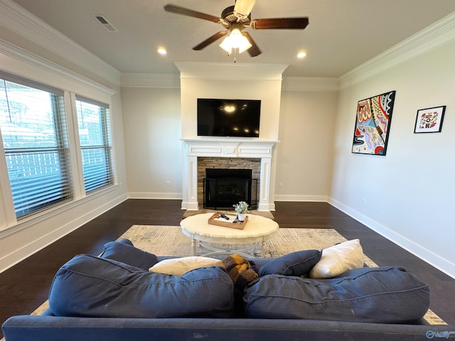 living area with a ceiling fan, visible vents, crown molding, a fireplace, and baseboards